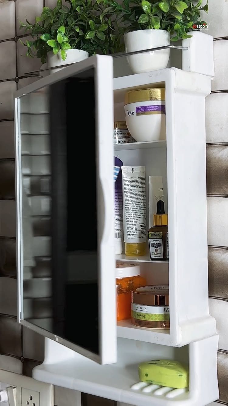 White wall-mounted medicine cabinet with an open mirror showing various skincare products inside.