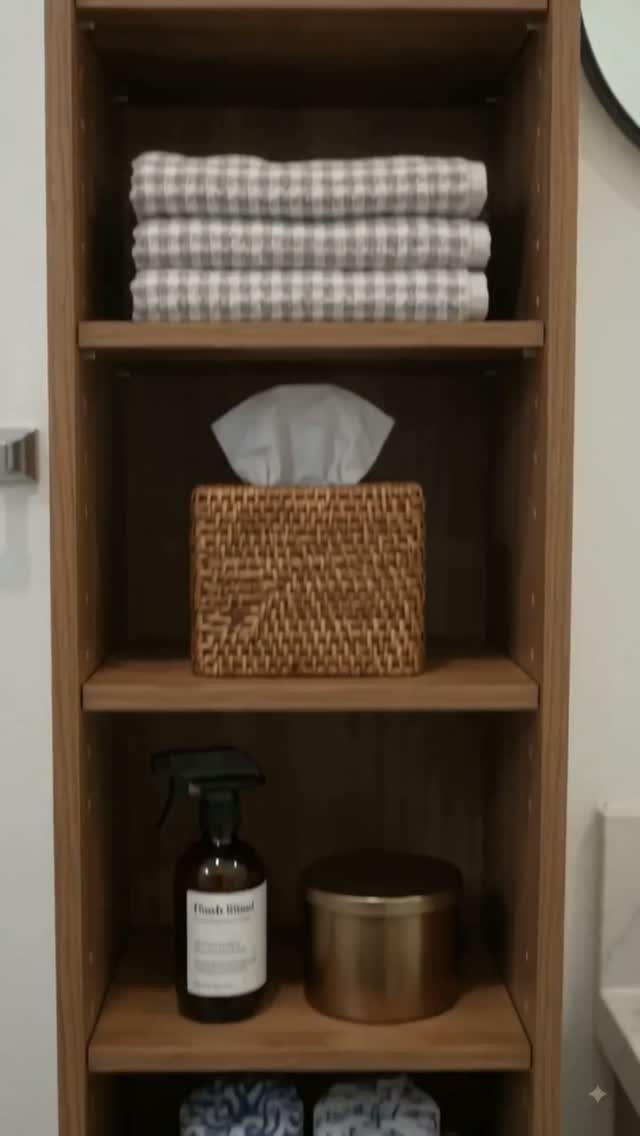 21 Bathroom Shelf Ideas That Make Tight Storage Work Harder 12 Wooden freestanding shelf unit holding folded towels, a woven basket, and various bathroom supplies.