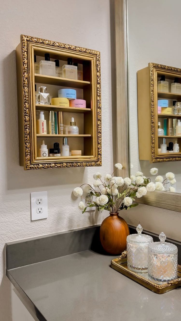 21 Bathroom Shelf Ideas That Make Tight Storage Work Harder 21 Gold ornate frame shelf filled with various perfume bottles and skincare products on a bathroom wall.