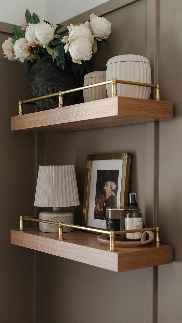 21 Bathroom Shelf Ideas That Make Tight Storage Work Harder 20 Two wooden floating shelves with brass railings holding decor and toiletries on a taupe wall.