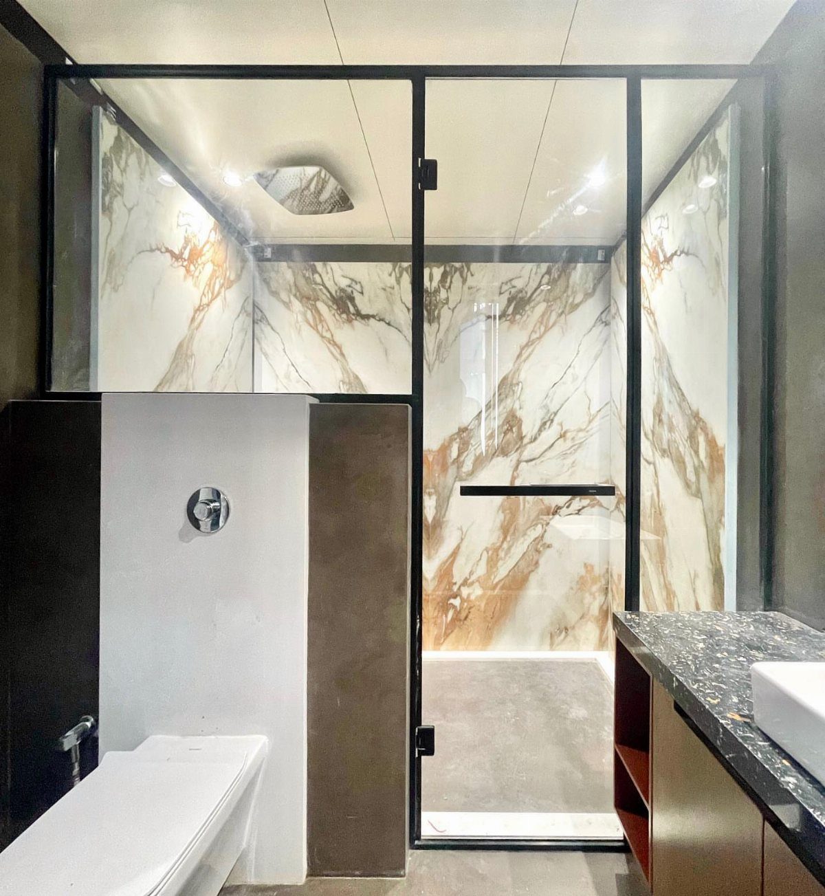 14 Bathroom Shower Ideas, From Rainfall Heads to Wet Rooms 11 A modern walk-in shower with black framed glass walls and marble patterned tiles.