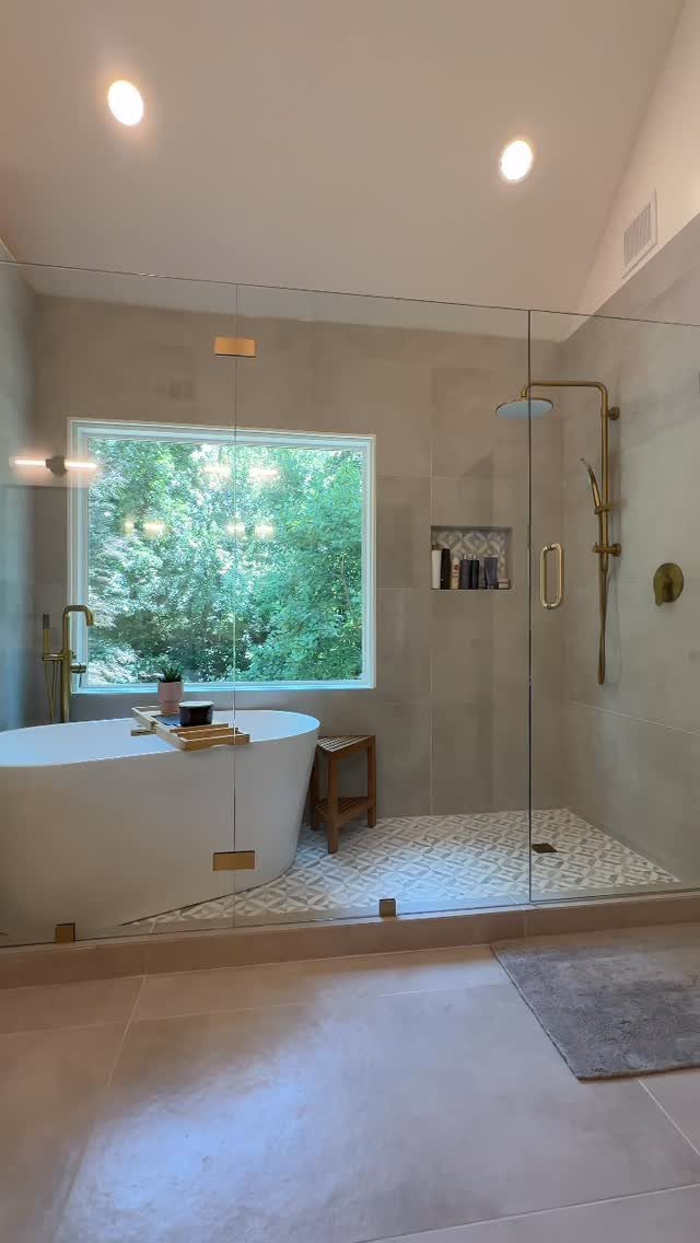 14 Bathroom Shower Ideas, From Rainfall Heads to Wet Rooms 9 A luxurious wet room featuring a white bathtub and a walk-in shower behind glass walls.