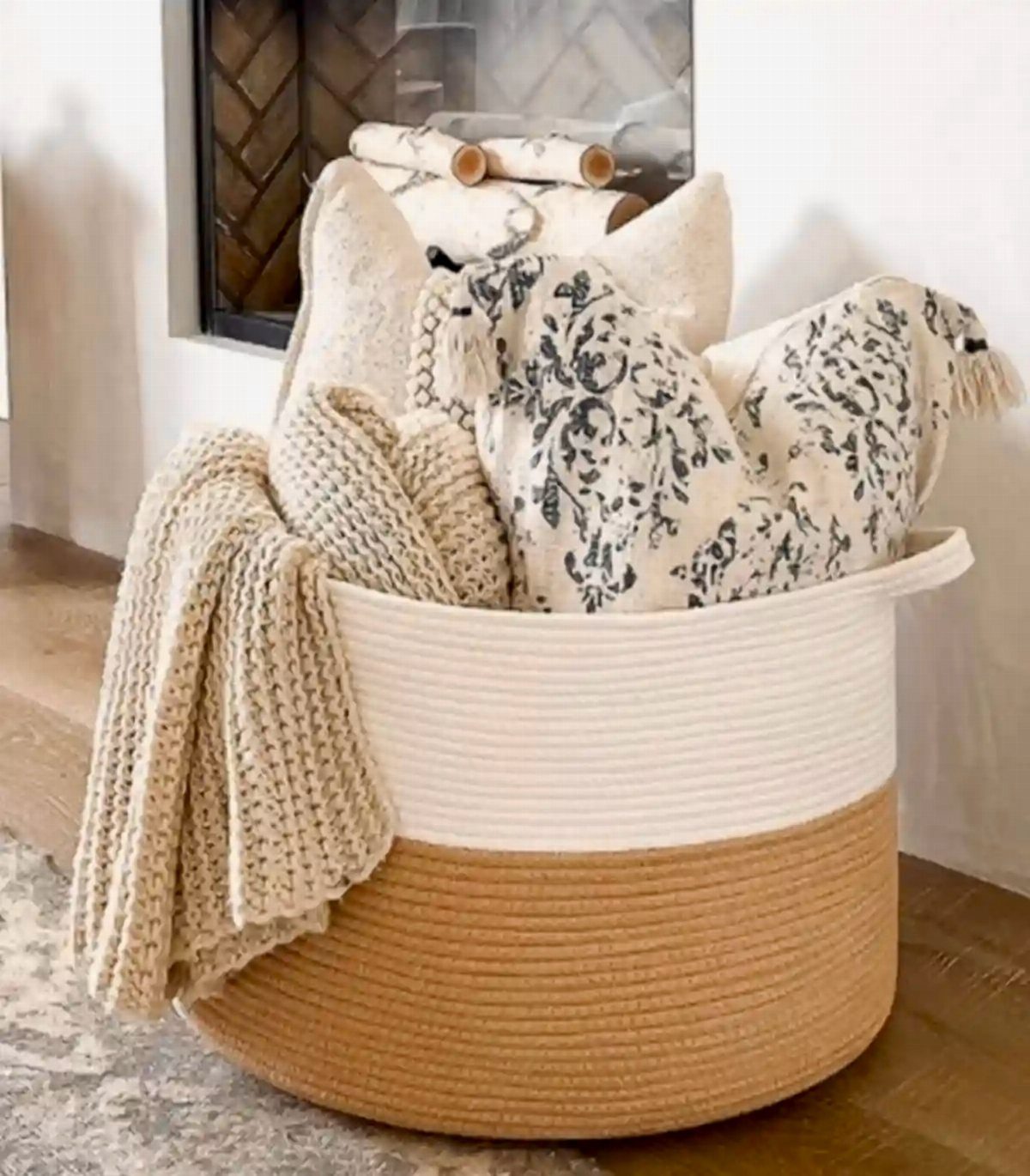 10 Blanket Storage Ideas for Small Spaces and Closets 6 A large white and tan rope basket filled with cozy textured blankets.