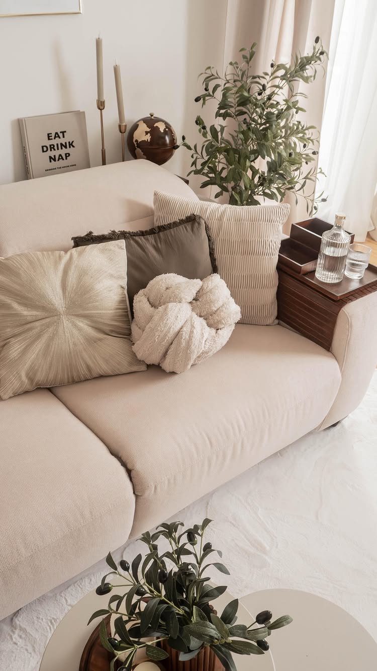 10 Blanket Storage Ideas for Small Spaces and Closets 7 Cream sofa featuring various decorative pillows including a large white knot pillow.