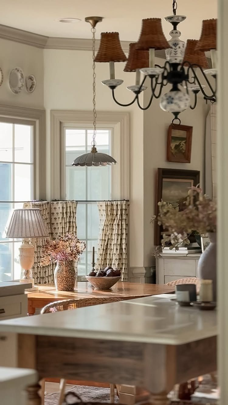 A dining room featuring a decorative chandelier, pendant light, and a lamp on a table.
