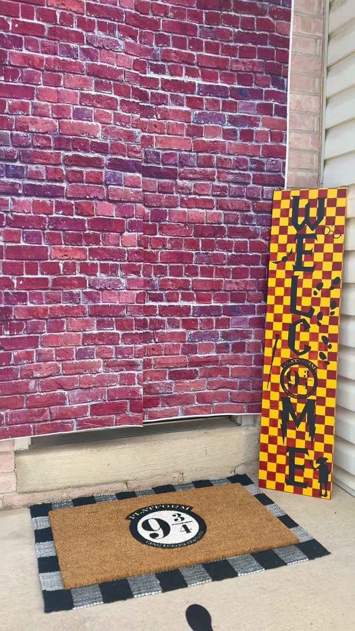 Platform 9 3/4 doormat with a checkered border sitting on a concrete step.
