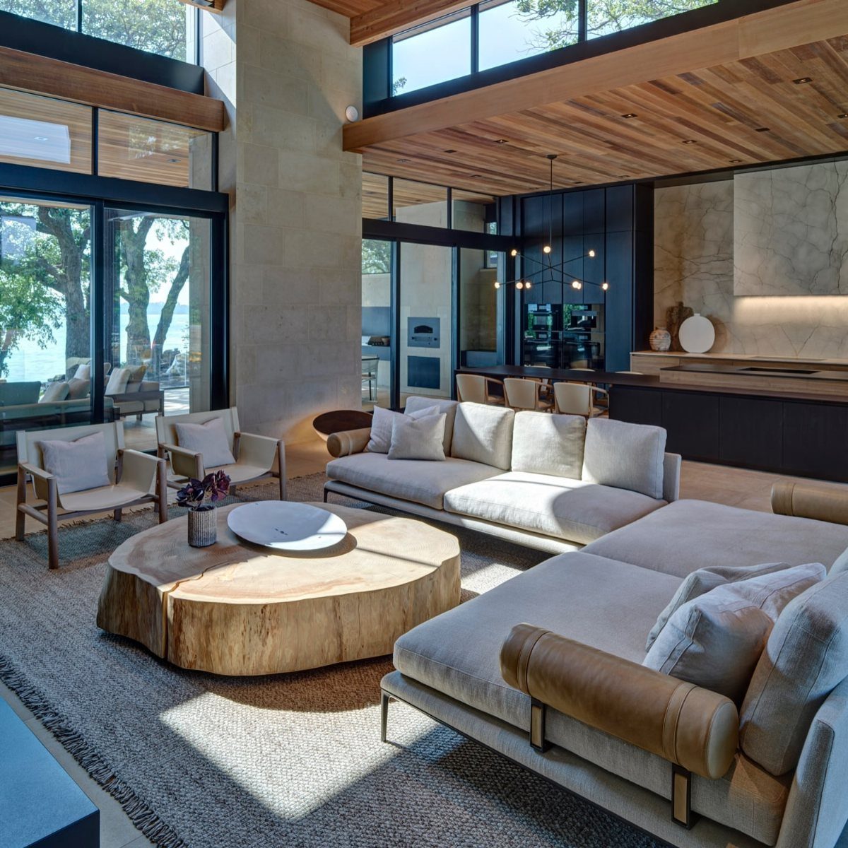 Modern living room with a large live-edge wood coffee table and stone pillar.