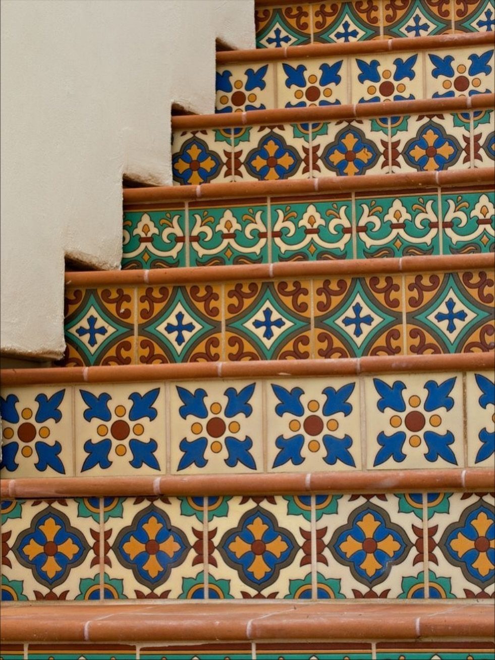 14 Mexican Decor Ideas for Every Room 6 Hand-painted decorative tiles with colorful geometric and floral patterns on staircase risers.