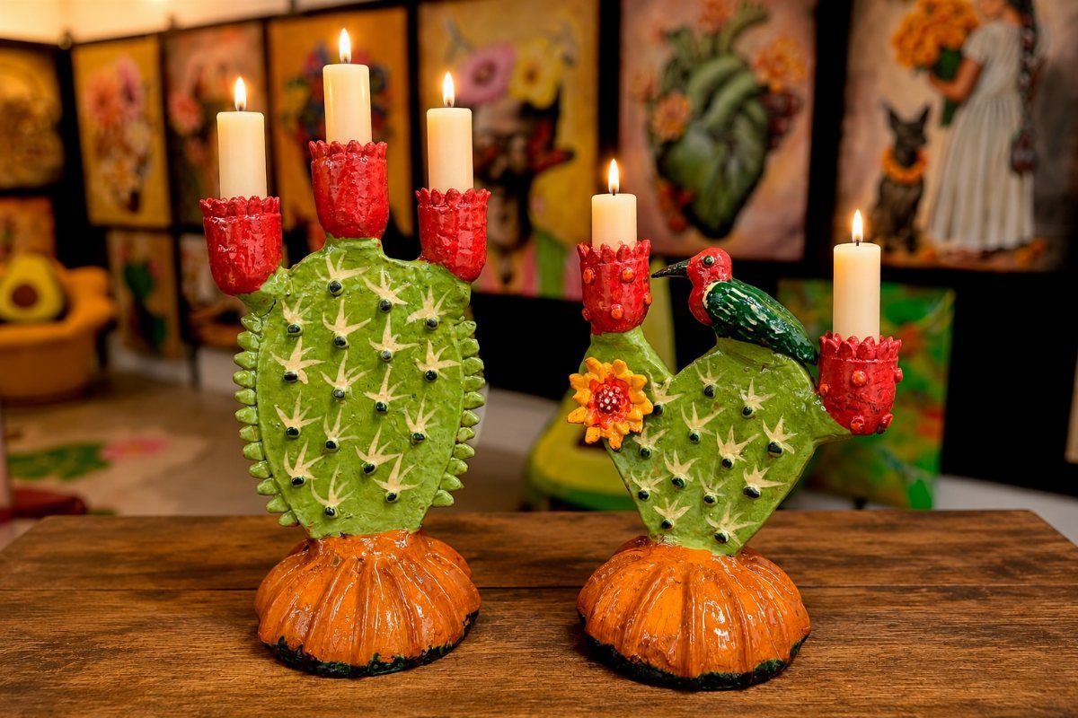 14 Mexican Decor Ideas for Every Room 2 Two green cactus-shaped ceramic candle holders with lit white candles on a wooden table.
