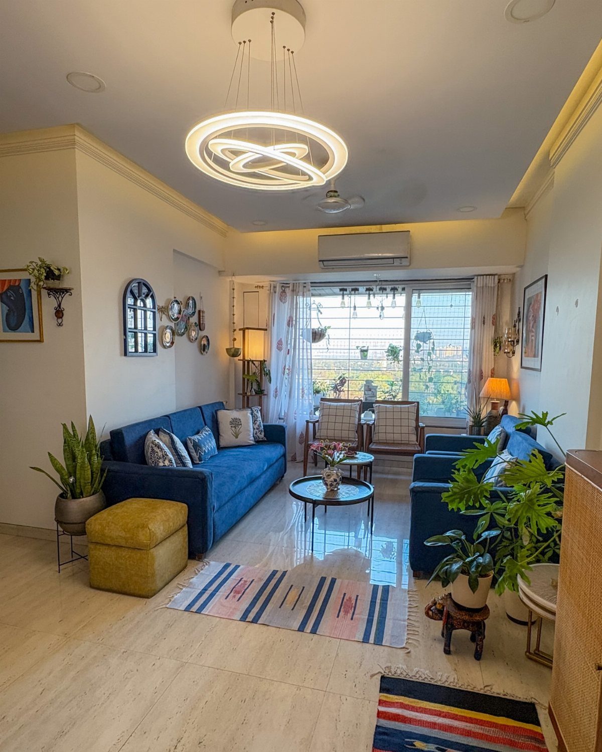 Two blue sofas facing each other across a small coffee table in a bright living room.